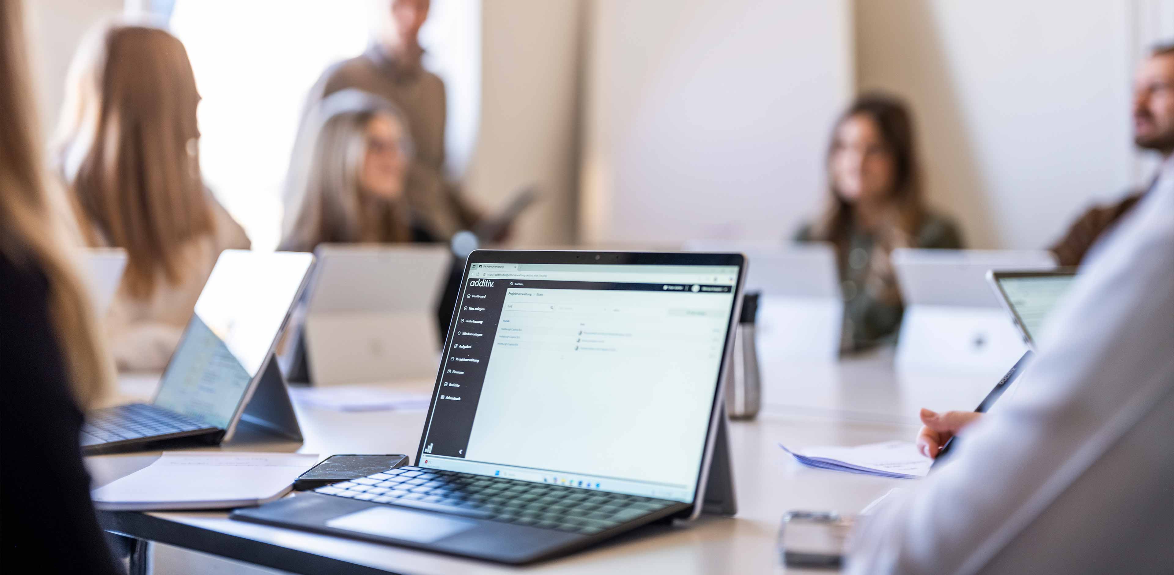 Team von additiv bei einer Besprechung am Konferenztisch